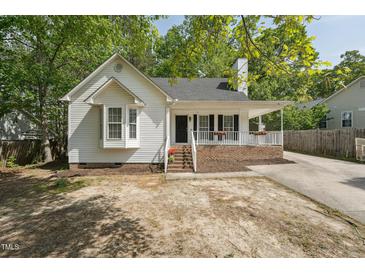 Charming one-story home with white siding, covered porch and beautiful landscaped front yard at 2028 Ruddy Rd, Raleigh, NC 27616