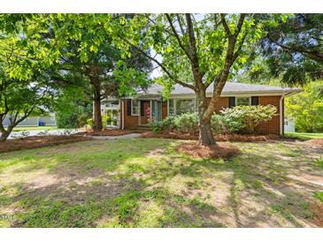 Charming brick home with mature trees and a well-manicured lawn at 209 N Occoneechee St, Hillsborough, NC 27278