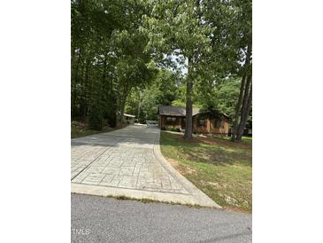 Cozy wood cabin with a beautiful, long driveway surrounded by mature trees creating a private and serene setting at 5601 Plum Nearly Ct, Raleigh, NC 27610