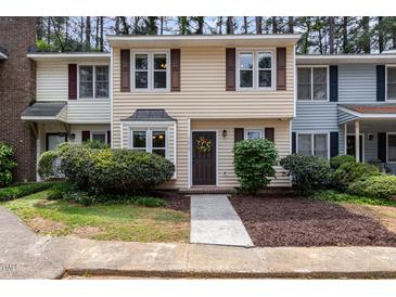Charming townhome featuring a well-manicured front yard and a welcoming, decorated front door at 7015 Staghorn Ln, Raleigh, NC 27615