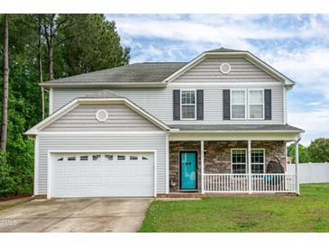 Charming two-story home with gray siding, stone accents, and a bright blue front door at 71 Hunters Way, Angier, NC 27501
