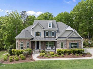 Beautiful two-story home with stone accents, a covered front porch, and manicured landscaping at 7517 Summer Pines Way, Wake Forest, NC 27587