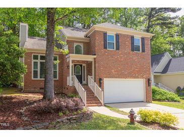 Charming brick home featuring well-manicured landscaping and an attached two-car garage at 8124 Greywinds Dr, Raleigh, NC 27615