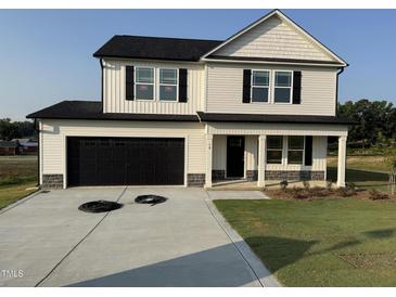 Charming two-story home with a black two-car garage and covered porch at 10 Silver Ct, Smithfield, NC 27577
