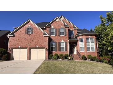 Charming two-story brick home featuring a two-car garage and well-manicured lawn at 102 Revere Forest Ct, Cary, NC 27519