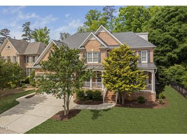 Charming two-story brick home with manicured lawn, mature trees, and inviting front porch at 107 Oxford Creek Rd, Cary, NC 27519