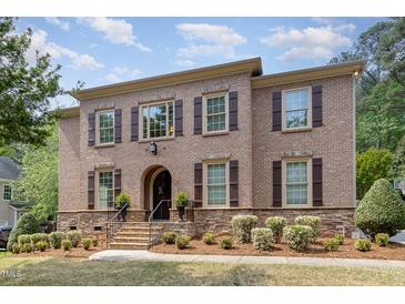 Charming two-story brick home with a landscaped front yard and classic architectural details at 112 Aspenridge Dr, Holly Springs, NC 27540