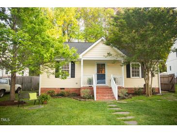 Charming single-story home featuring a well-manicured lawn and inviting front porch at 112 E Edgewood Dr, Durham, NC 27704