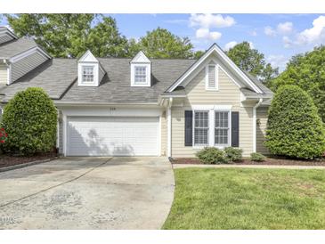 Charming home featuring a two-car garage, dormer windows, and manicured landscaping at 115 White Lake Ct, Cary, NC 27519