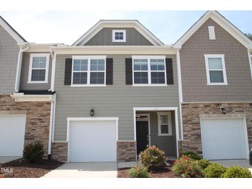 Charming townhome with a one-car garage, stone accents, and attractive curb appeal at 123 Hunston Dr, Holly Springs, NC 27540