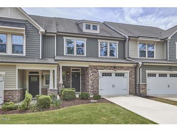 Charming townhome showcasing a stone facade, attached garage, and inviting curb appeal with manicured lawn at 1238 Exchange Pl, Durham, NC 27713