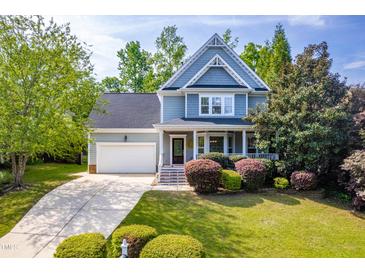 Charming two-story home featuring a well-manicured lawn, mature trees, and a welcoming front porch at 1241 Dalgarven Dr, Apex, NC 27502