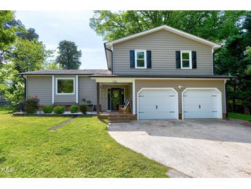 Charming two-story home featuring neutral siding, black shutters, a two-car garage, and well-maintained landscaping at 1321 Bloomingdale Dr, Cary, NC 27511