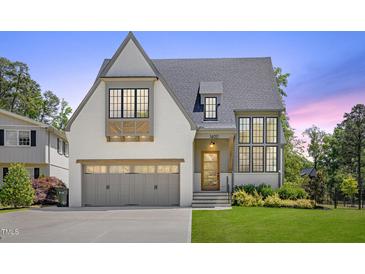 Beautiful two-story home with a gray roof, gray garage door, and nicely manicured front lawn at 1400 Hedgelawn, Raleigh, NC 27615