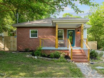 Charming brick home with a cozy front porch and beautifully landscaped front yard at 1402 W Lakewood Ave, Durham, NC 27707