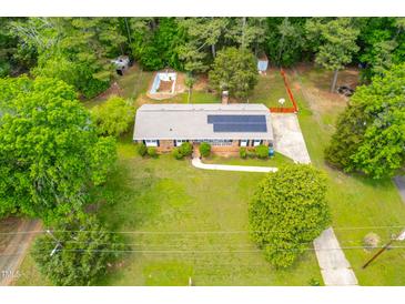 Charming home with solar panels, pool, and fenced yard surrounded by lush trees at 149 Baldwin Dr, Durham, NC 27712