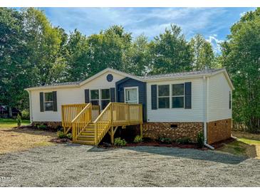 Charming single-story home with a wooden deck and beautiful landscaping at 1622 Julian Oakley Rd, Rougemont, NC 27572