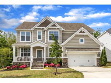 Charming two-story home featuring a manicured lawn, stone accents, and a two-car garage at 1811 Sandoval Dr, Durham, NC 27703