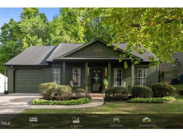 Charming single-story home with a beautifully landscaped front yard and attached garage at 1820 Collier Rd, Durham, NC 27707