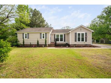 Charming single story home featuring manicured lawn, flower garden, and neutral exterior at 2005 Chalybeate Springs Rd, Fuquay Varina, NC 27526