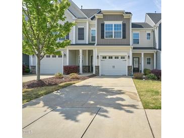 Charming townhome featuring a one-car garage and a well-maintained lawn and shrubbery at 225 Gulley Glen Dr, Garner, NC 27529