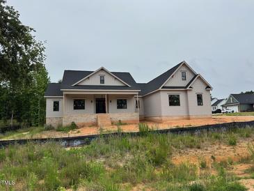 Charming single-Gathering home featuring a welcoming front porch and a beautifully landscaped yard at 27 Batten Hill Ln, Selma, NC 27576