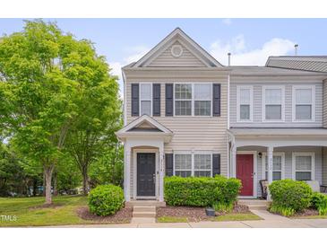 Charming two-story townhouse with black shutters, landscaped yard and lush green tree in front at 3114 Courtney Creek Blvd, Durham, NC 27713