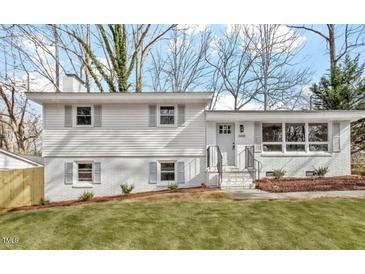 Charming home featuring new white paint, gray shutters, fresh landscaping, and a well-manicured front yard at 3408 Brentwood Rd, Raleigh, NC 27604