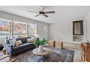 Cozy living room with neutral colors, ceiling fan, large windows, and contemporary furniture at 3408 Brentwood Rd, Raleigh, NC 27604
