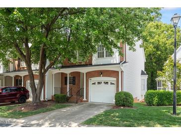 Charming two-story townhouse with a one car garage, brick accents, and beautiful landscaping at 4540 Mistiflower Dr, Raleigh, NC 27606