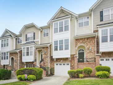 Charming townhouse with a stone facade, inviting entrance, and attached garage at 5026 Celtic Ct, Raleigh, NC 27612