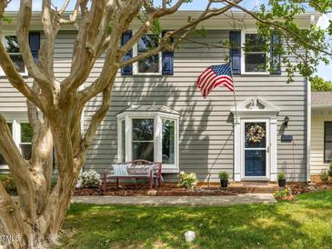 Charming home featuring a patriotic display with an American flag and blue shutters enhancing the curb appeal at 6718 Twin Tree Ct, Raleigh, NC 27613