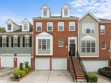 Charming brick townhome with a two-car garage, landscaped front yard, and inviting staircase entrance at 703 Kirkeenan Cir, Morrisville, NC 27560