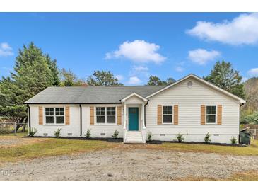 Charming single story home with white siding, wood shutters, and a vibrant blue front door at 8201 Rhodes Rd, Apex, NC 27539