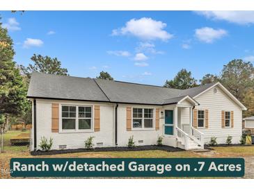 Charming white brick ranch home featuring a teal front door and light brown window shutters at 8201 Rhodes Rd, Apex, NC 27539