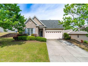 Charming home with well-manicured front yard, lush landscaping, and a convenient two-car garage at 8525 Holdenby Trl, Raleigh, NC 27616