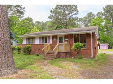Charming brick home featuring pink shutters, a well-kept lawn, and inviting curb appeal at 107 Glosson Cir, Carrboro, NC 27510