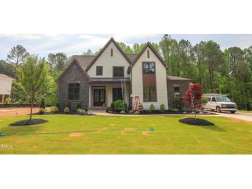 Beautiful two-story home boasts a manicured lawn and a blend of stone and siding accents for striking curb appeal at 1108 Delilia Ln, Wake Forest, NC 27587