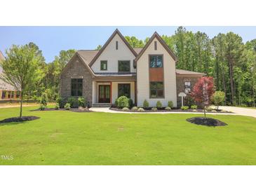 Stunning home featuring a manicured lawn, stone accents, and a welcoming front entrance at 1108 Delilia Ln, Wake Forest, NC 27587