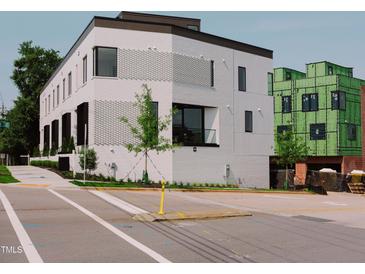 Modern white brick home showcasing unique architectural details and manicured landscaping at 1303 Chamblee Hill Ct, Raleigh, NC 27608