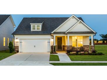 Charming two-story home with a well-maintained lawn, covered porch, and attached garage at 1606 Garden Park Cir, Fuquay Varina, NC 27526