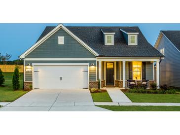 Charming single-Gathering home boasting a well-manicured lawn and an attached two-car garage at 1614 Garden Park Cir, Fuquay Varina, NC 27526