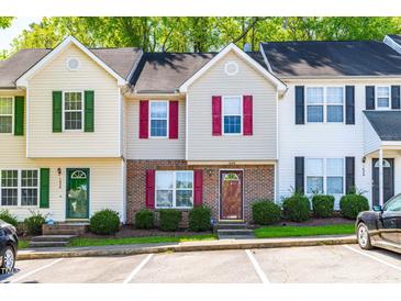 Exterior view of charming townhomes with colorful shutters and landscaped front yards at 1628 Briarmont Court Ct, Raleigh, NC 27610