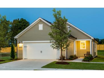 Charming home featuring a two-car garage, covered entryway and professionally landscaped front yard at 1630 Garden Park Cir, Fuquay Varina, NC 27526