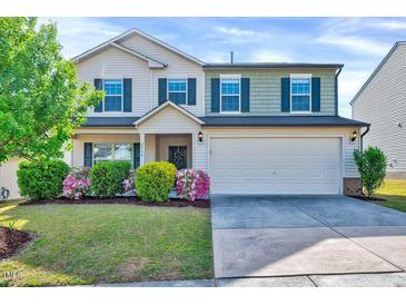 Charming two-story home featuring a well-manicured lawn, colorful shrubs, and a two-car garage at 2540 Averon Dr, Fuquay Varina, NC 27526