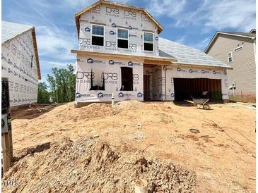 Exterior view of a new construction home showing windows and a garage on a partially cleared lot at 27 Spring Crest Dr # 69, Angier, NC 27501