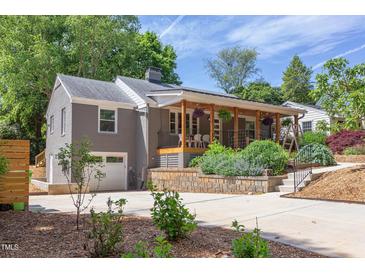 Charming home featuring a welcoming front porch, an attached garage, and a well-maintained, landscaped front yard at 2811 Van Dyke Ave, Raleigh, NC 27607