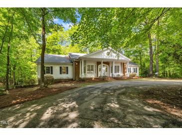 Charming brick and white home nestled among trees with a circular driveway at 2901 Horse Shoe Farm Rd, Wake Forest, NC 27587