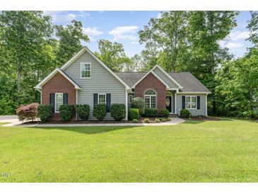 Charming single-Gathering home with brick and siding, surrounded by a lush green lawn and mature trees at 315 Copper Ridge Dr, Sanford, NC 27330