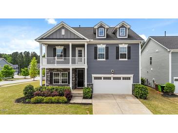 Charming two-story home featuring stone accents, a balcony, and a two-car garage at 316 Barley Mill Rd, Holly Springs, NC 27540